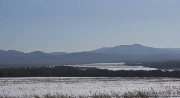 Kış manzarası, tarlada karlı yol, etraftaki ağaçlar ve tepeler