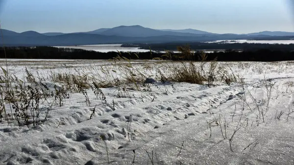 Kış manzarası, tarlada karlı yol, etraftaki ağaçlar ve tepeler