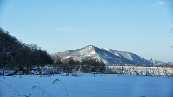 Kış manzarası, tarlada karlı yol, etraftaki ağaçlar ve tepeler