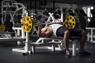 Güçlü atletik adam bir halter kaldırmaya hazırlanıyor