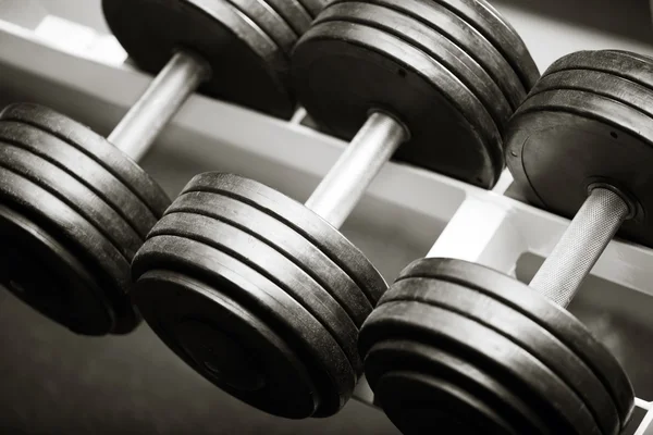 Drie metalen dumbbells liggend op een rij — Stockfoto