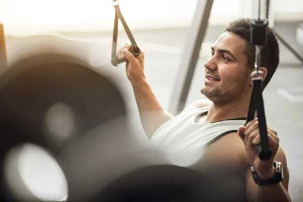 Alegre hombre positivo haciendo ejercicio en un gimnasio — Foto de Stock