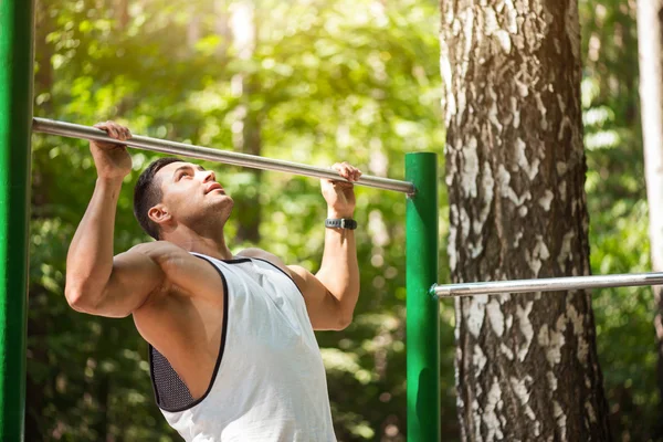 Pleasant hard working man doing chin ups — Stock Image Pleasant hard working man doing chin ups Royalty Free Stock Photos