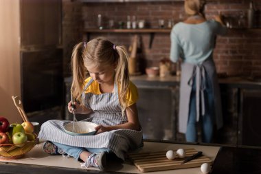 İşin içinde kız masada oturan yumurta karıştırma