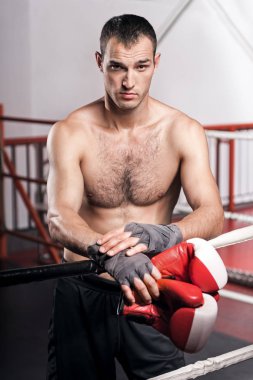 Adam boks eldiven tutarak yüzük ipe yaslanmış