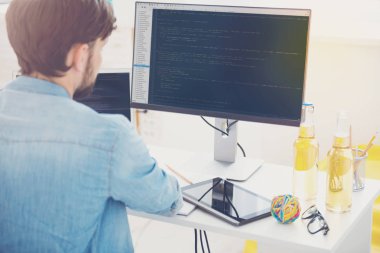 İddialı programcı bir ofiste bir bilgisayarda çalışma