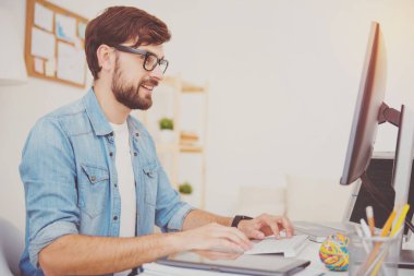 Bir ofiste çalışan gözlük gülümseyen programcı