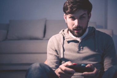 Konsantre adam evde videogames oynarken