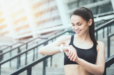 Akıllı bir saat stadium yanında kullanan gülümseyen kız