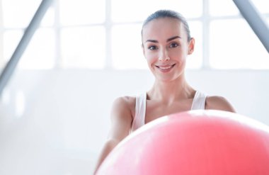 Pembe fitness topu tutan güzel mutlu kadın