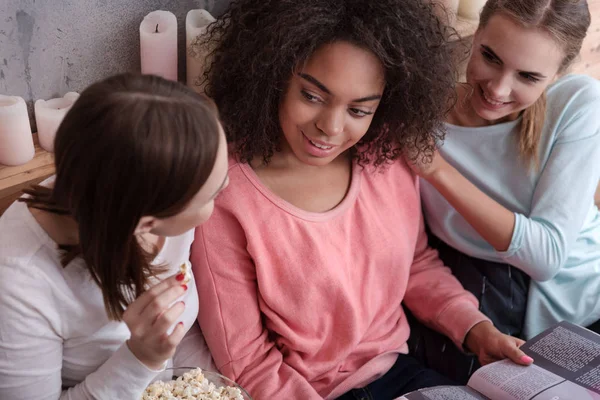 Ragazze deliziate che discutono la rivista alla festa di casa — Foto Stock