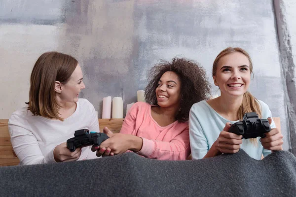 Sonrientes chicas jóvenes jugando juegos en el dormitorio en casa —  Fotos de Stock