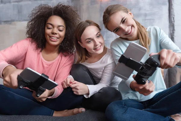Вовлеченные молодые девушки играют на игровых консолях — стоковое фото