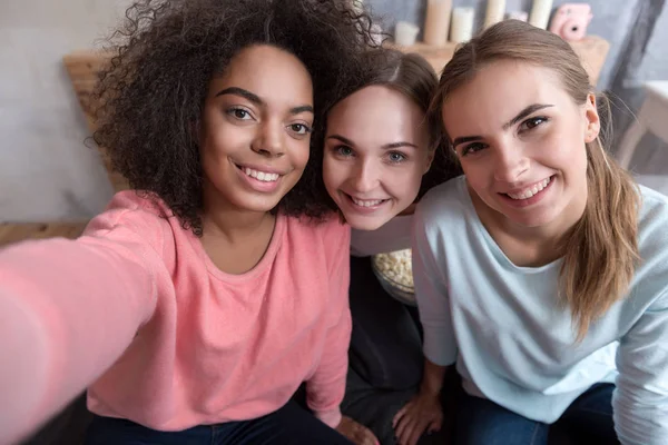 Jóvenes amigos sonrientes tomando selfie en el dormitorio en casa —  Fotos de Stock