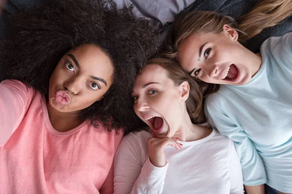 Pleasant girls taking selfie and playing ape at home — Stock Photo, Image