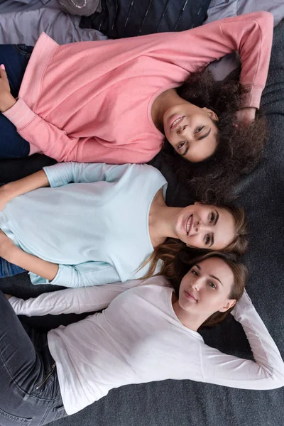 Meninas bonitas deitadas na cama no quarto — Fotografia de Stock