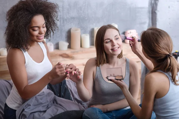 Pleasant girls helping her friend getting ready at home — Stock Photo, Image