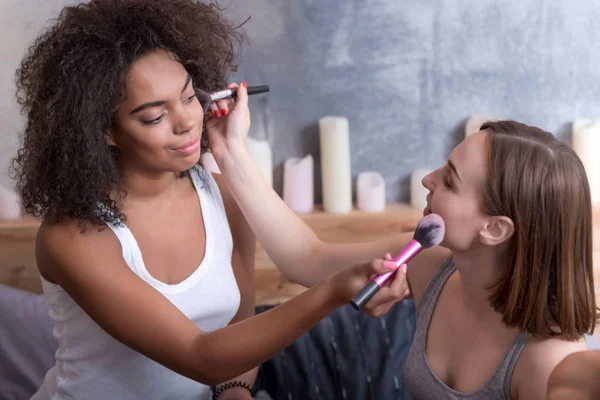 Очарованные молодые девушки накладывают макияж друг на друга — стоковое фото