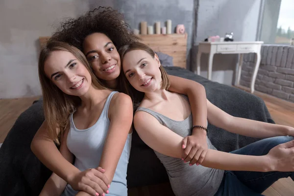 Amigos sonrientes abrazándose en el dormitorio en casa —  Fotos de Stock