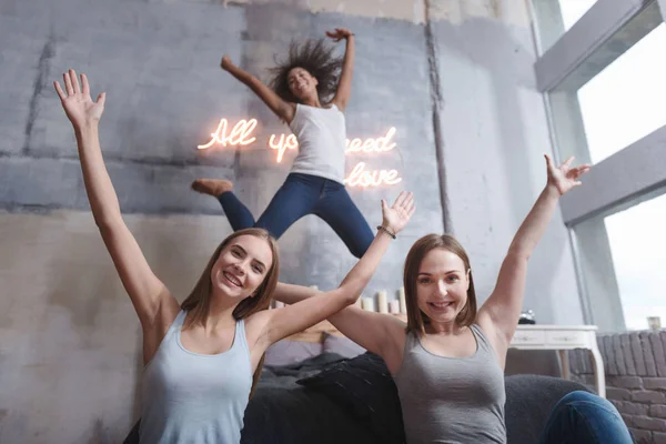 Menina alegre pulando e se divertindo com amigos — Fotografia de Stock