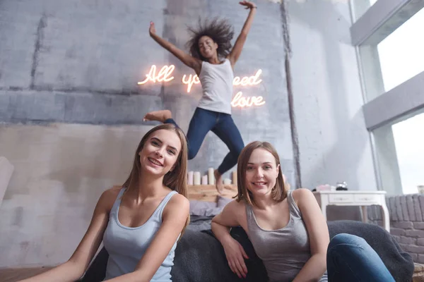 Menina encantada pulando e se divertindo com amigos — Fotografia de Stock