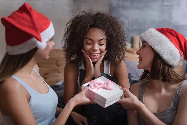 Delighted girls giving presents to each other — Stock Photo, Image