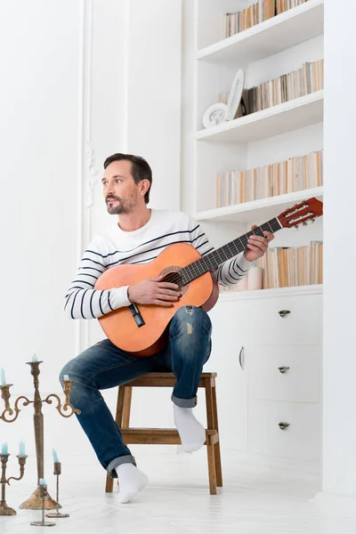 Bonito homem talentoso segurando a guitarra — Fotografia de Stock