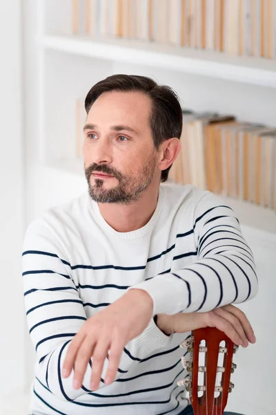 Guapo hombre confiado apoyando sus manos en la guitarra — Foto de Stock