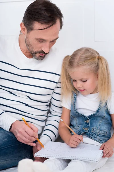 Ernst gut aussehender Mann erklärt seiner Tochter etwas — Stockfoto