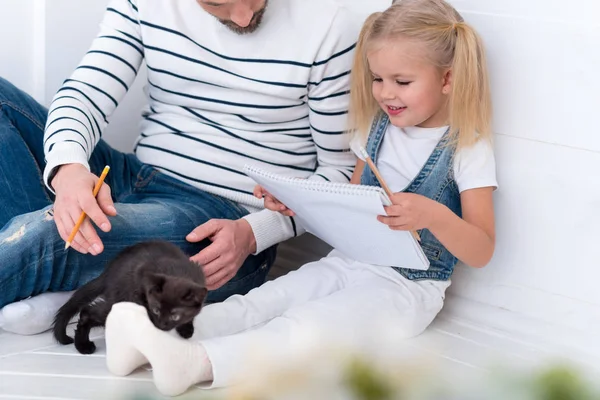 Nettes glückliches Mädchen mit einem Skizzenbuch — Stockfoto