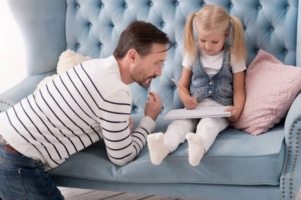 Bello padre premuroso che guarda il quaderno di sua figlia — Foto Stock