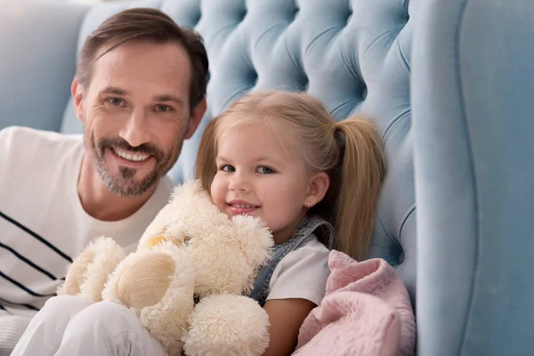 Vrolijke happy meisje zit met haar vader — Stockfoto