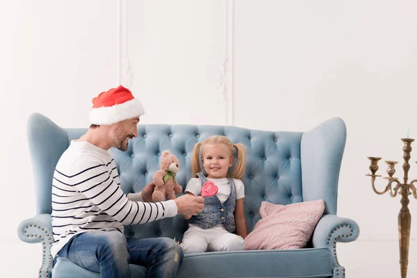 그의 딸에 게는 사탕을 주는 행복 한 명랑 한 사람 — 스톡 사진