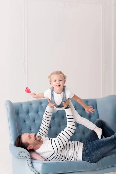 Feliz padre amoroso entreteniendo a su hijo — Foto de Stock