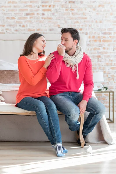 Angenehme fürsorgliche Ehefrau unterstützt ihren kranken Mann — Stockfoto