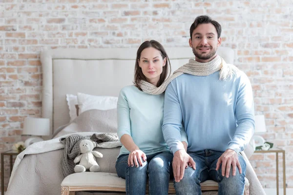 Cheerful positive couple sitting next to each other — Stock Photo, Image