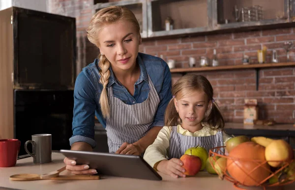 Deliziata ragazza avendo pinna con sua madre in cucina — Foto Stock