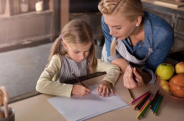 Deliziosa madre che disegna con sua figlia in cucina — Foto Stock