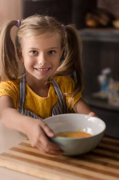 Lächelndes kleines Mädchen, das die Schale mit den zerbrochenen Eiern hält — Stockfoto