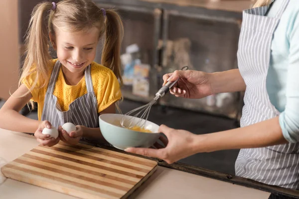 Задоволена дівчина допомагає мамі на кухні — стокове фото