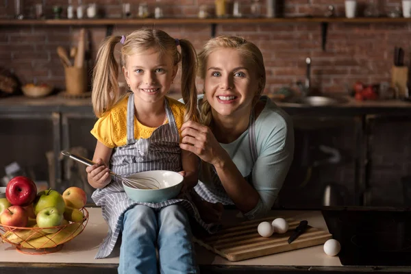 台所で母親と一緒に料理の小さな娘の笑顔 — ストック写真