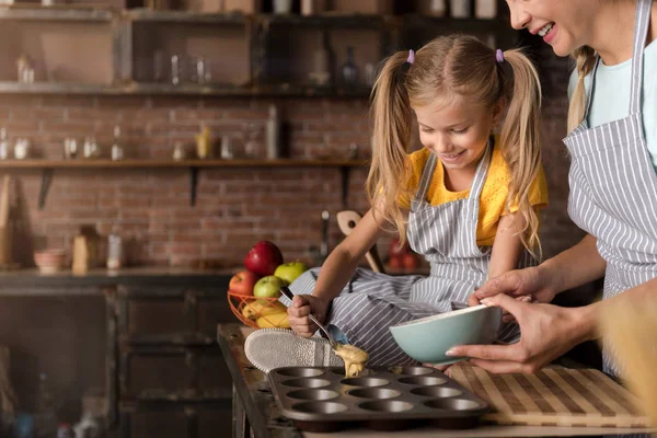 Uśmiechający się udział dziewczyna pomaga jej matka gotowanie ciasto — Zdjęcie stockowe