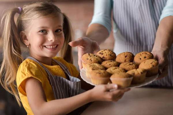 Ευτυχής κορίτσι γεμάτο muffins πλατώ — Φωτογραφία Αρχείου