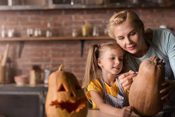 Involved daughter preparing a pumpkin for Halloween with her mother — Stock Photo, Image