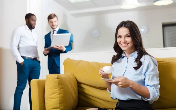 Positiv lächelnde Frau, die sich auf der Couch ausruht — Stockfoto