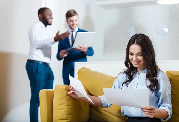 Empresária positiva trabalhando com papéis — Fotografia de Stock