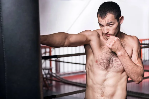 Hombre boxeando el saco de boxeo en el gimnasio —  Fotos de Stock