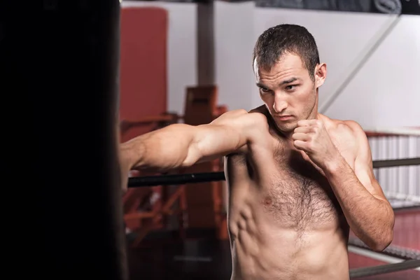Чоловік боксерський мішок в спортзалі — стокове фото