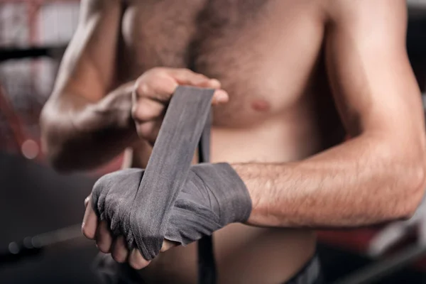 Gros plan de l'homme enveloppant la main dans du ruban de boxe — Photo