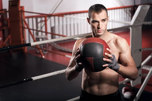 Homem muscular segurando bola fitness na frente do peito — Fotografia de Stock